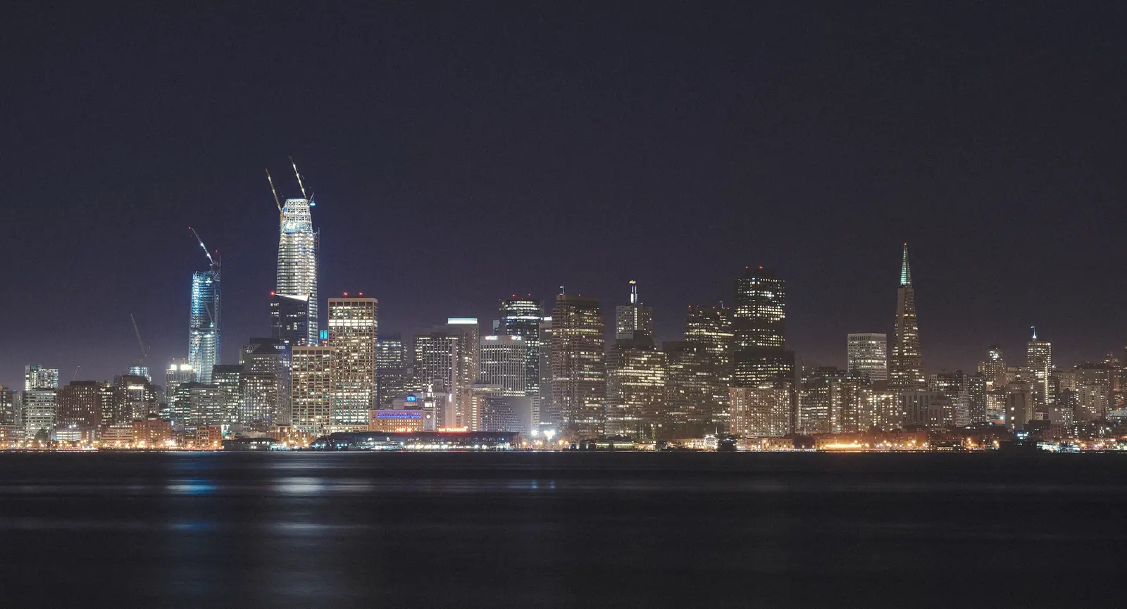 Photo of the lit San Francisco skyline across the water at night