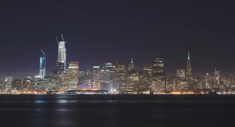 Photo of the lit San Francisco skyline across the water at night